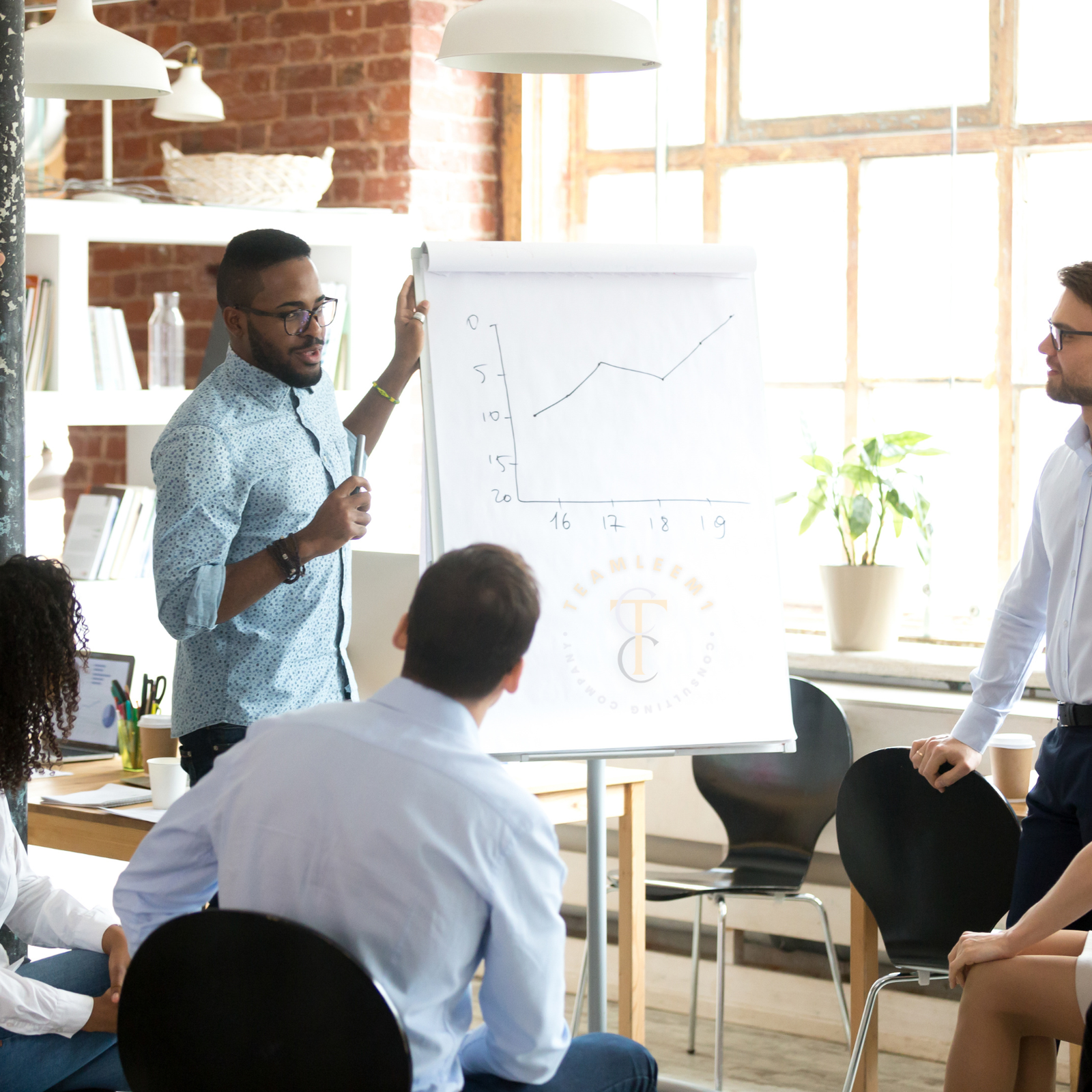 A few people in a meeting room during a whiteboard presentation.